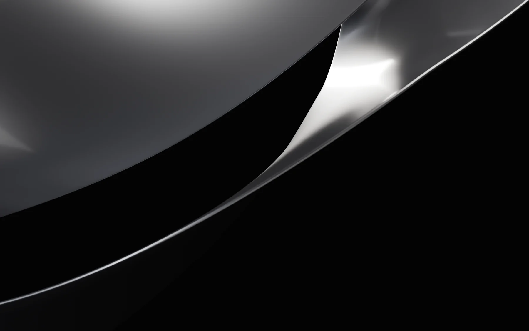 A macro render of the ribbon’s edge: a curled band of graphite metal with a thin line of light along its bevel, the rest in soft focus.